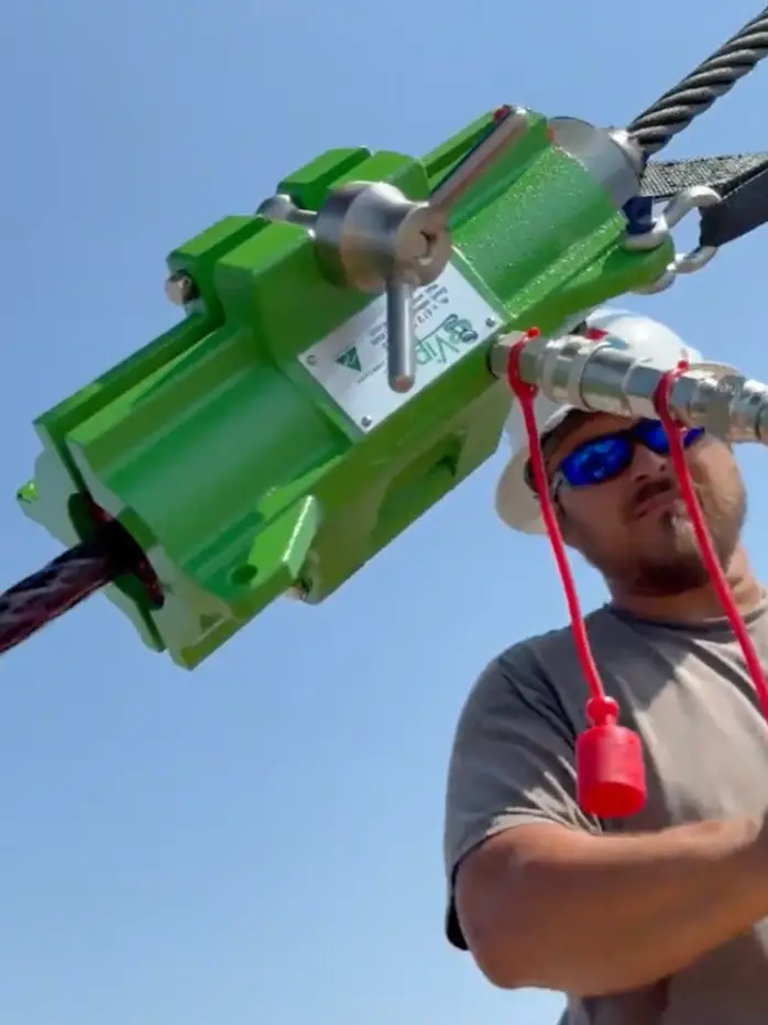 Man in a hard hat performing wire rope lubrication