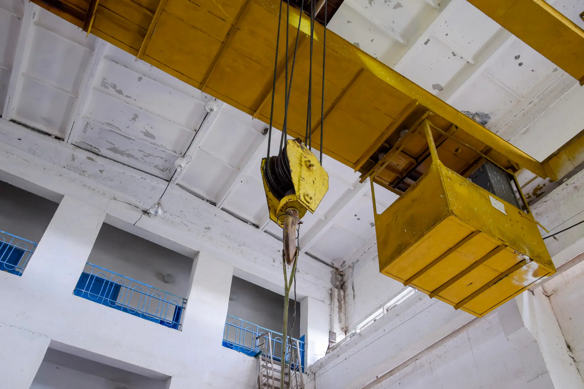 Hoist with winch and hook. A tool for moving goods in a production room. Mechanization of labor.