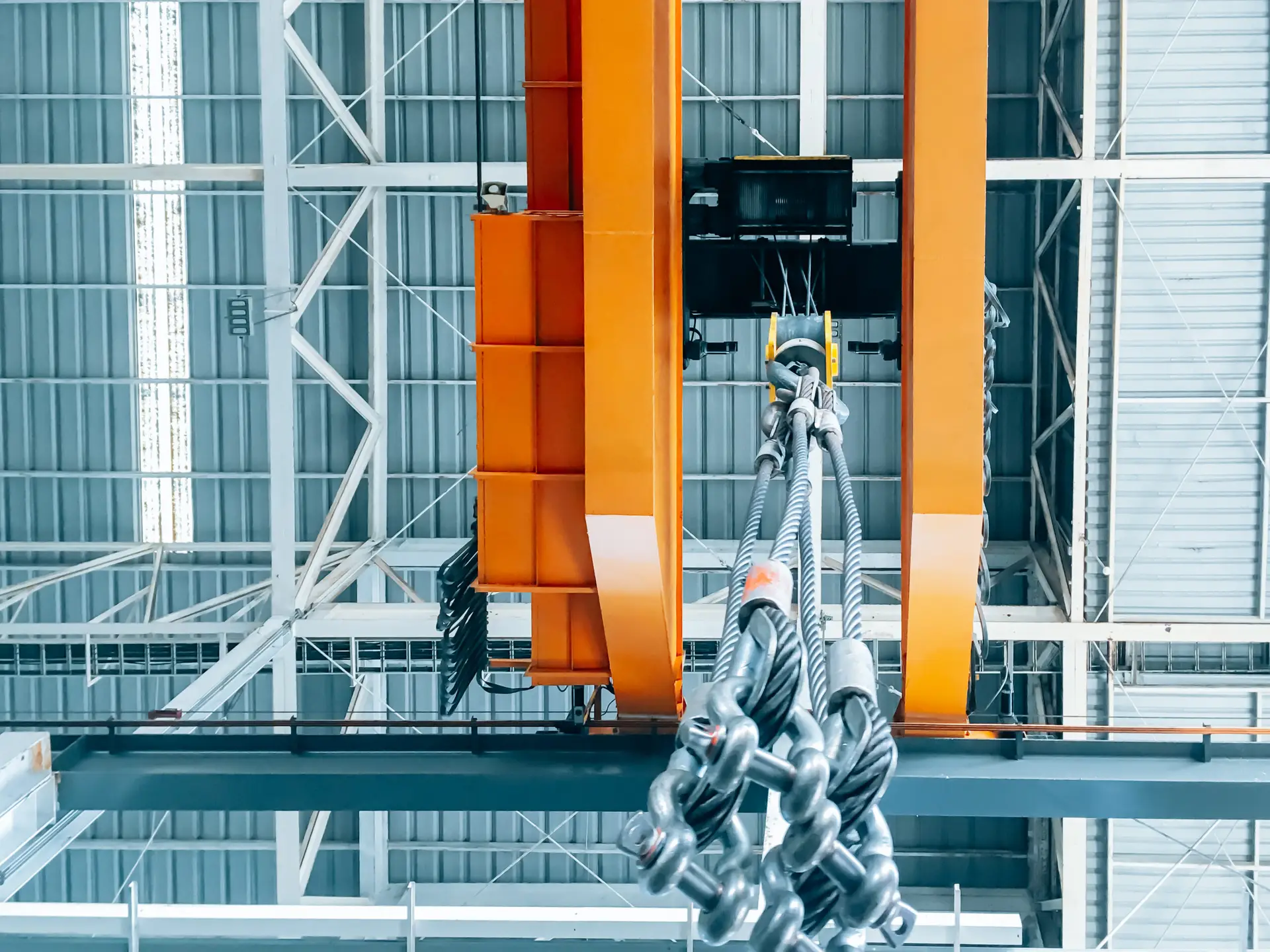 Overhead crane and machine inside factory building, industrial background.